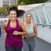 Three young women exercising by running in the city.