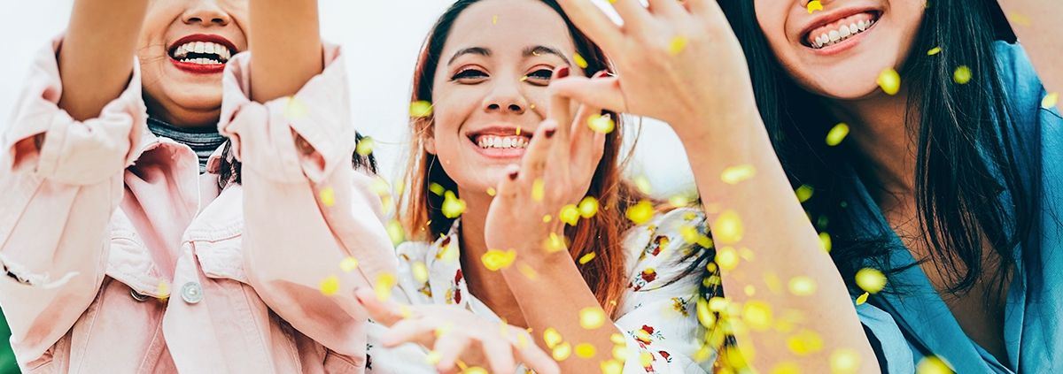 Three young asian women throwing confetti in excitement.