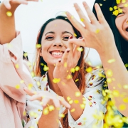 Three young asian women throwing confetti in excitement.