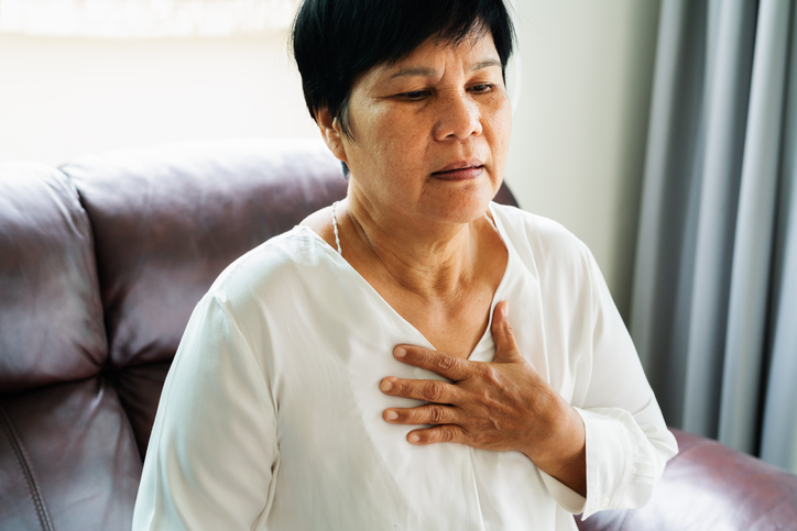 old woman having heart attack and grabbing her chest, dealing with heart disease in women.