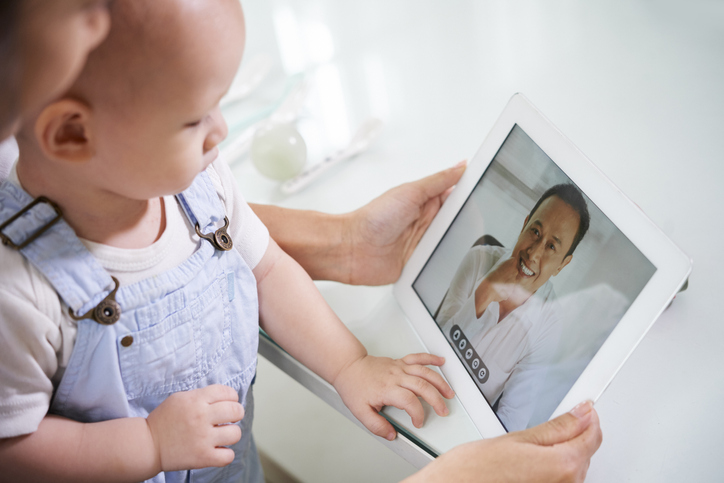 Woman with baby video calling husband.