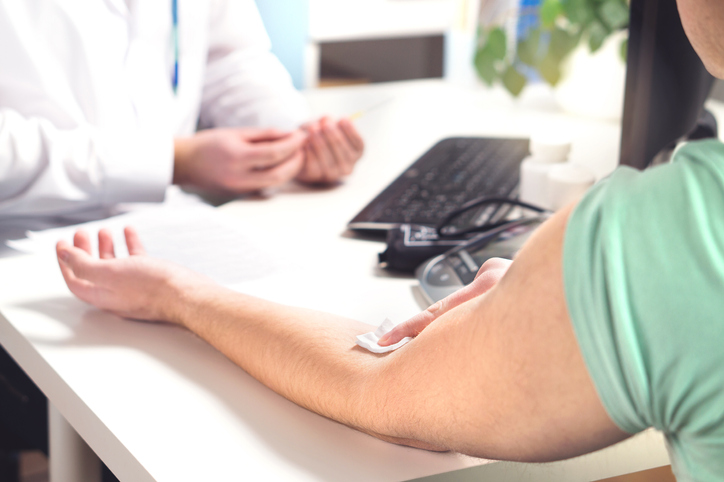 Blood test, sample or donation concept. Doctor with patient in hospital office, emergency room or laboratory. Person holding swab on arm after injection. Nurse holding needle., discussing why stds testing is important.