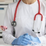 gynecologist in office near model of uterus and ovaries