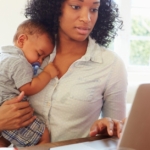 Mother with baby working in home office