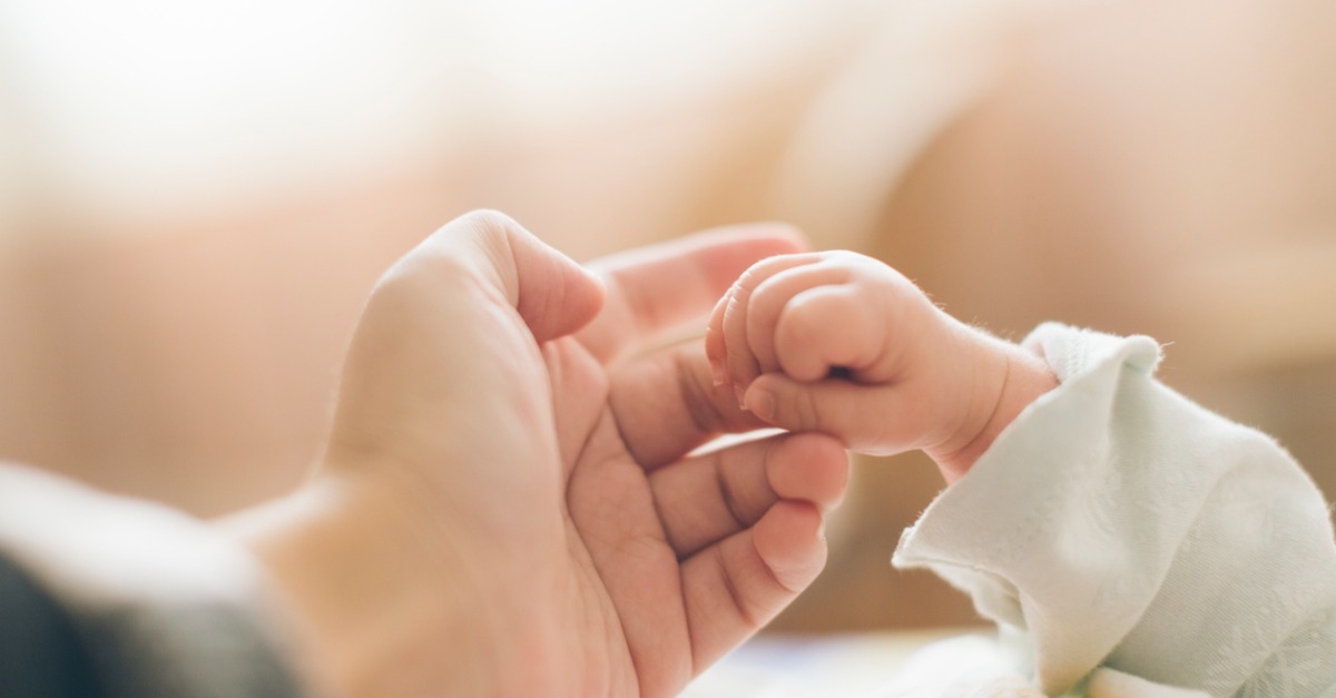 adult and baby hands holding