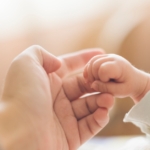 adult and baby hands holding