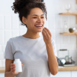 woman taking vitamins in kitchen