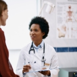 Doctor speaking to woman during medical appointment