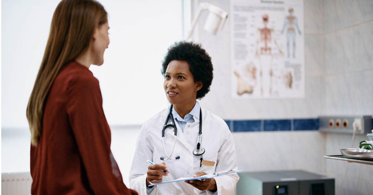 Doctor speaking to woman during medical appointment