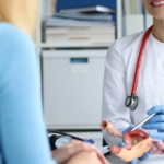 gynecologist holds model of female reproductive system