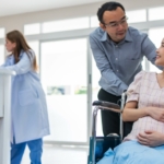 man with pregnant woman in a wheel chair at a hospital