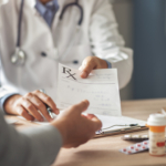 Physician handing a patient a prescription during an office visit