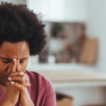 A menopausal woman sitting at a desk, looking distracted while experiencing brain fog and memory concentration difficulty.