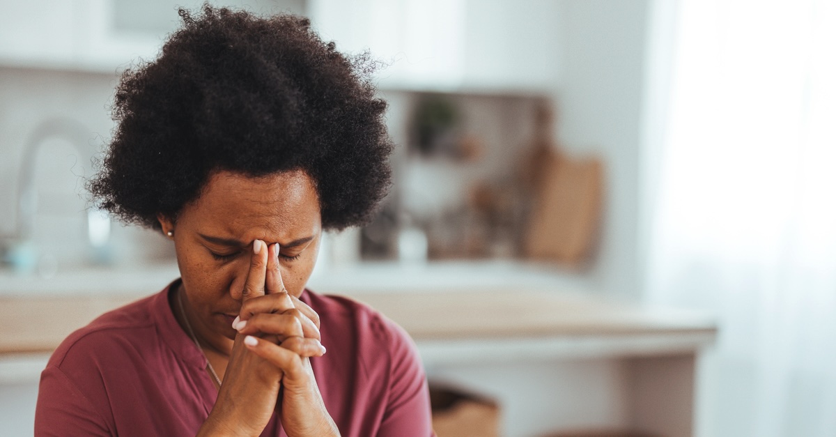 A menopausal woman sitting at a desk, looking distracted while experiencing brain fog and memory concentration difficulty.